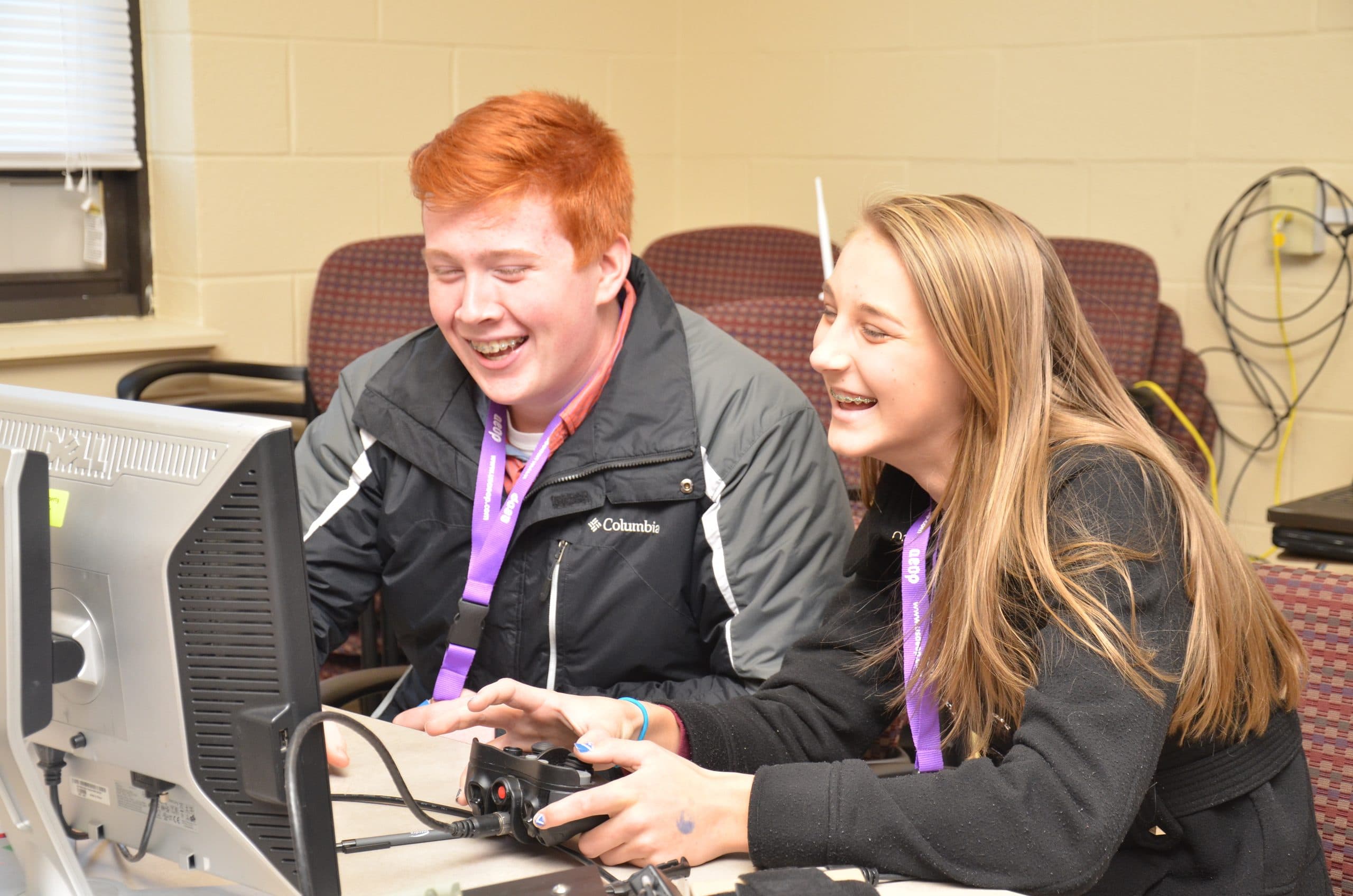 Adolescentes rindo juntos em atividade de tecnologia