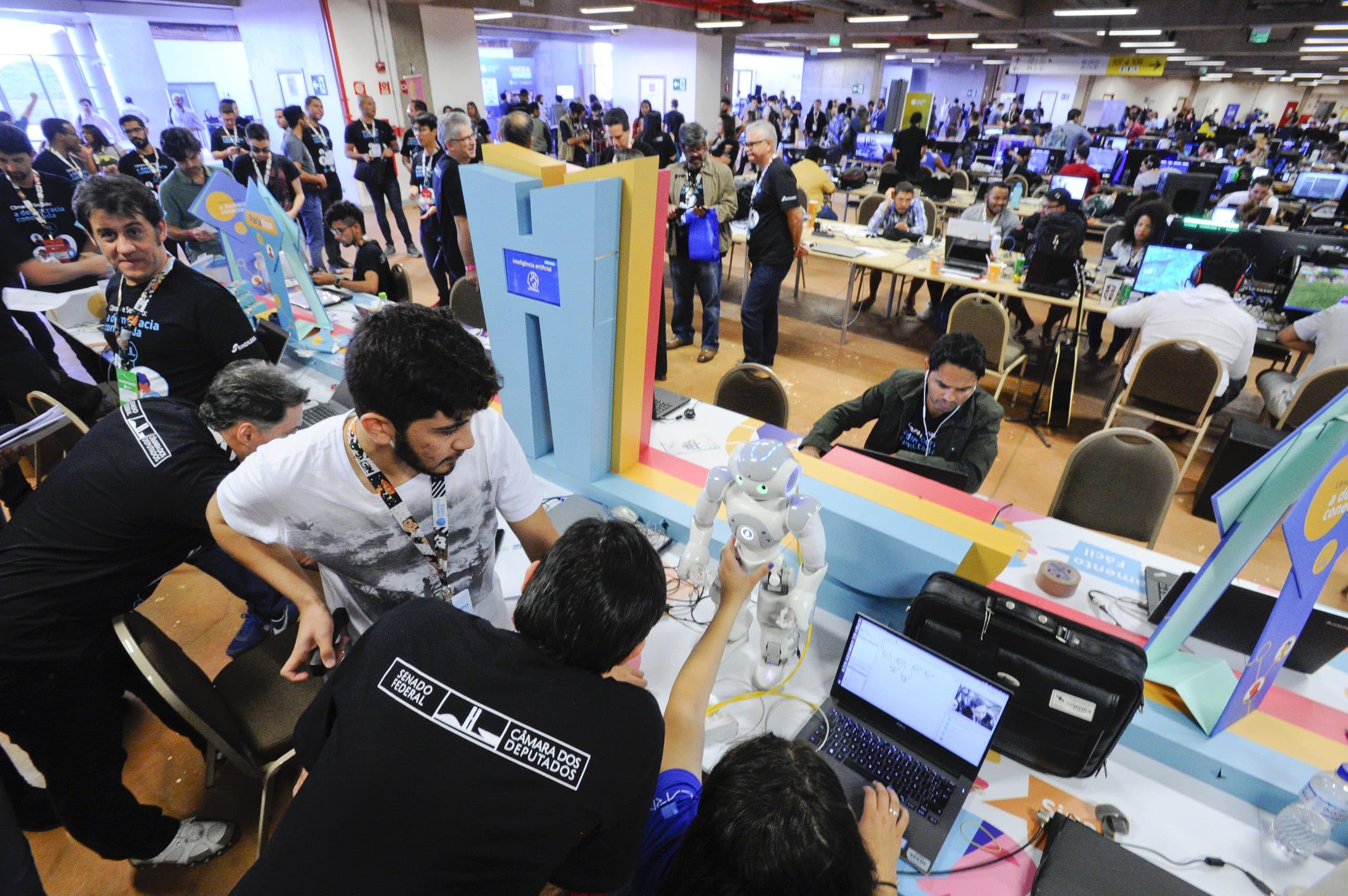 Estudantes programando robôs humanoides em hackathon