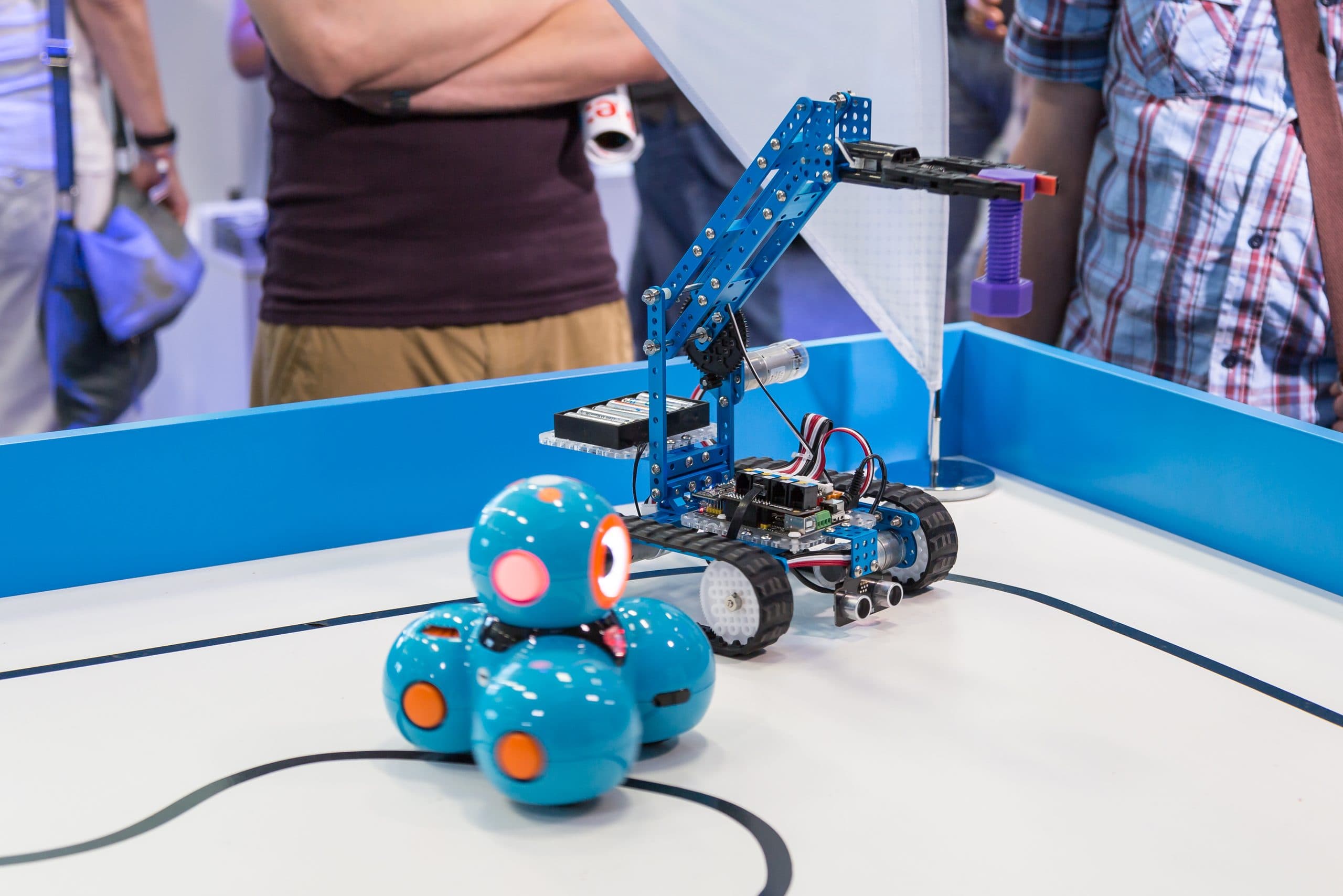 Robôs coloridos em mesa de feira maker